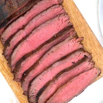 Overhead of sliced steak on carving board.