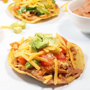 Single tinga tostada with garnishes.
