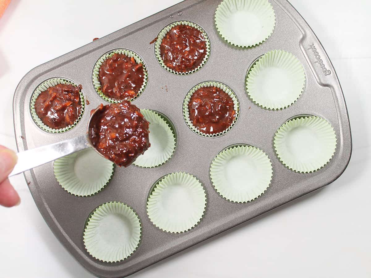 Filling the cupcake liners with carrot cake batter.