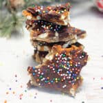 Chocolate Bark with pretzels stacked on white table.