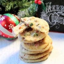 Stack of peppermint chip cookies with Merry Christmas in background.