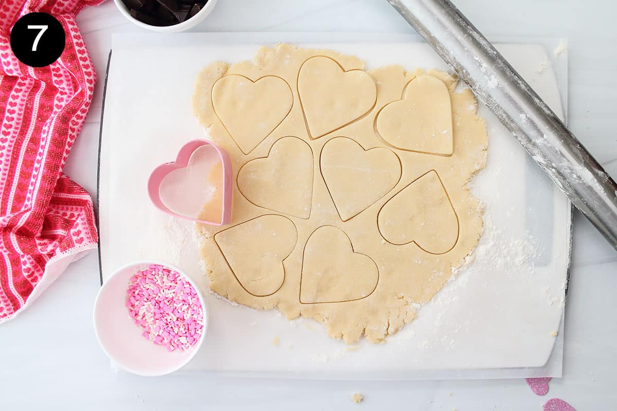 Cutting heart shapes out of rolled out dough.