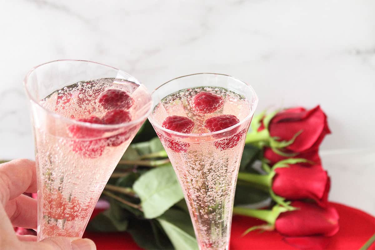 Clicking two Valentine's Day cocktails together for celebration.