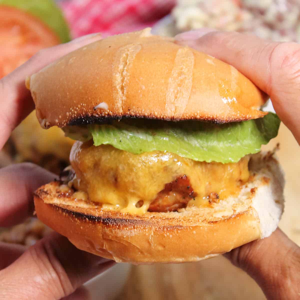 Closeup holding chorizo and beef burger.