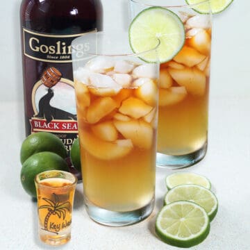 Dark and Stormy cocktails with lime slice and dark rum.