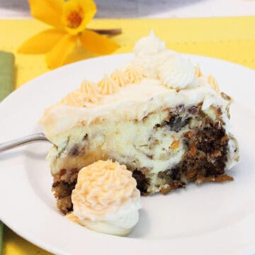 Closeup of Cheesecake Factory Carrot Cake Cheesecake slice with frosting.