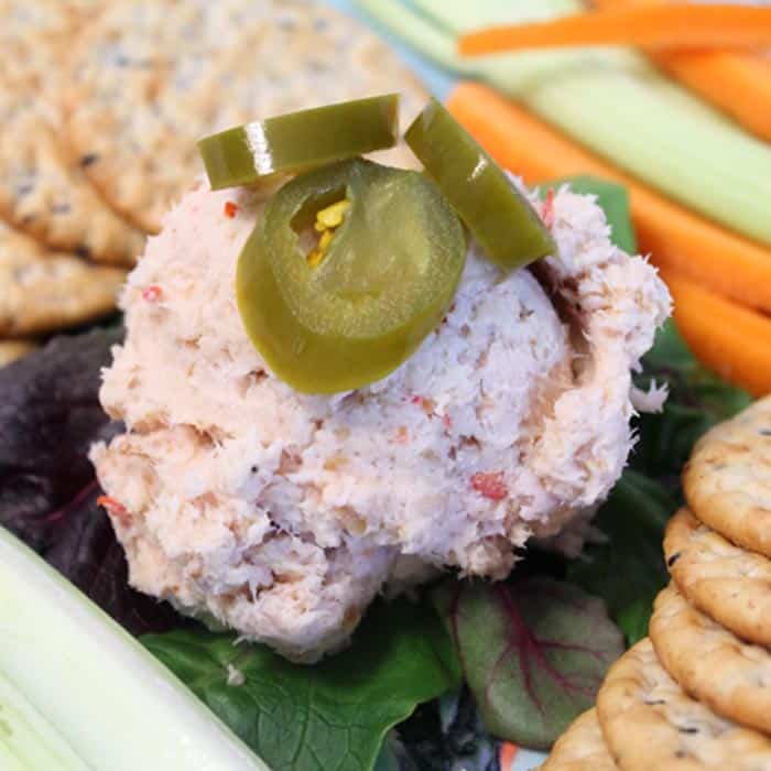 Closeup of fish dip beside crackers and celery.