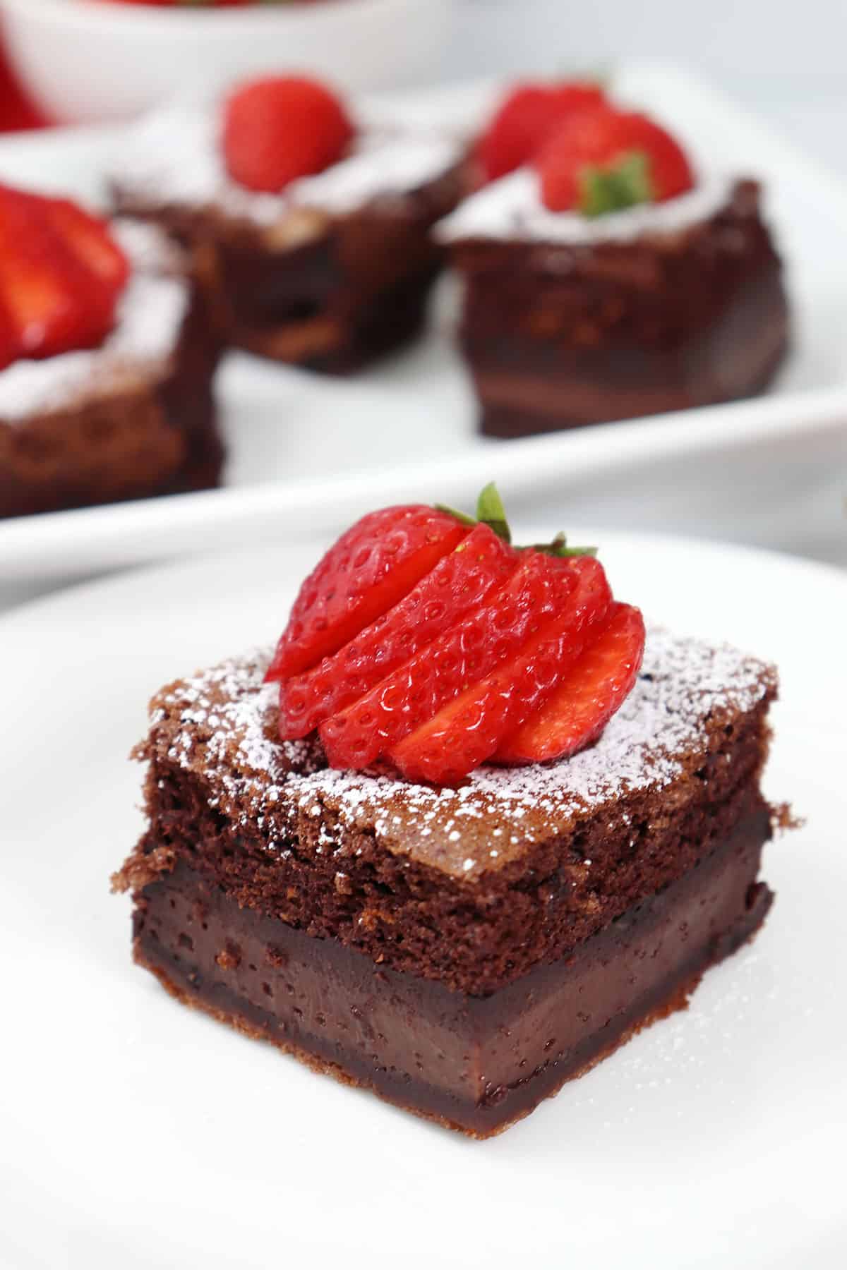 Chocolate Magic Cake slice with strawberry garnish.
