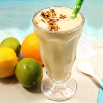 Closeup of citrus smoothie with straw.