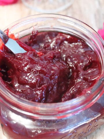 Overhead closeup of plum jam in mason jar.