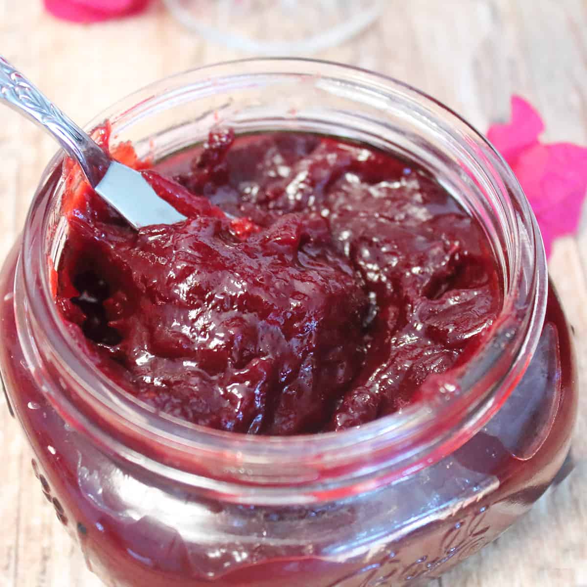 Overhead closeup of plum jam in mason jar.