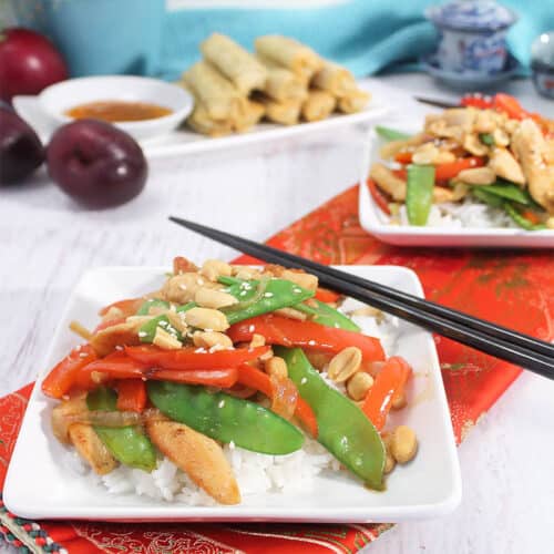 healthy chicken stir fry served for dinner on white plates with chop sticks.