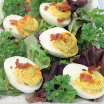 Deviled eggs on platter with greens.