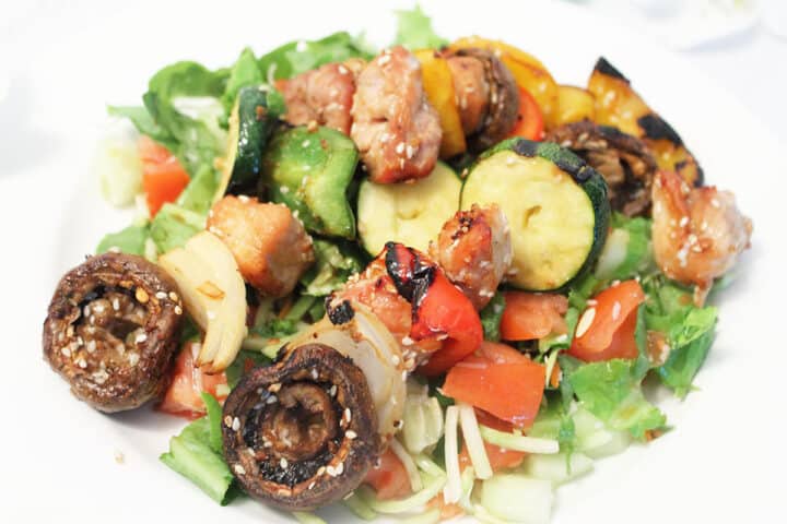 Korean BBQ Kabobs unskewered and served over salad.