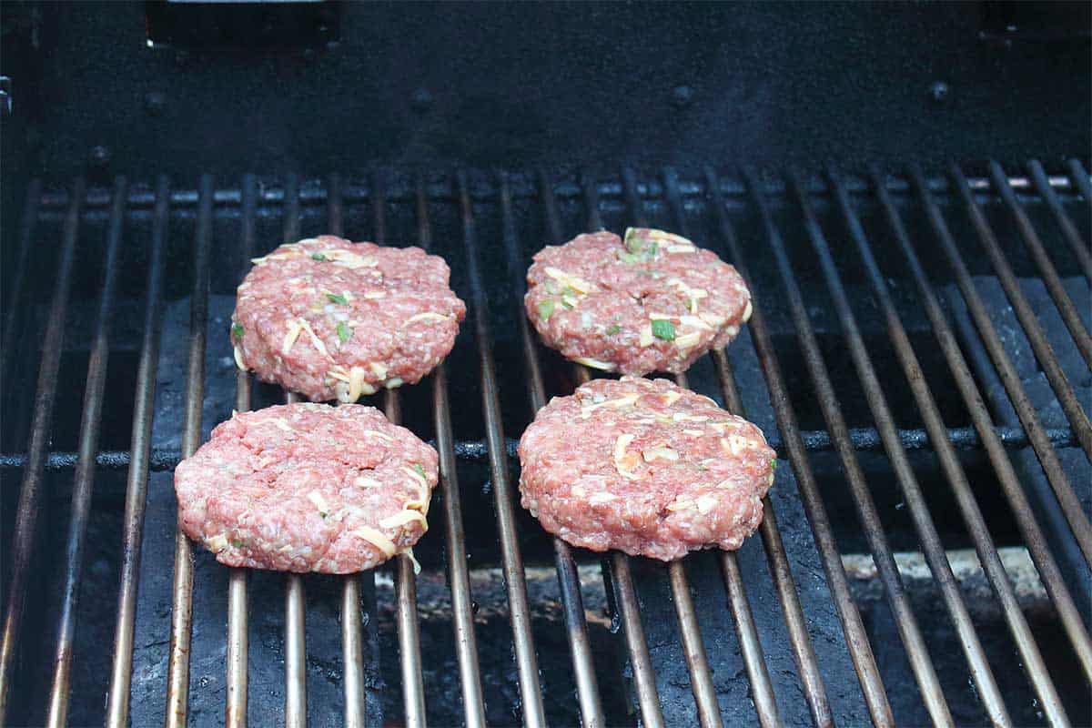 Cooking burgers on hot grill.