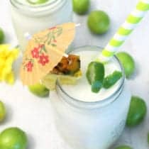 Overhead of colada in mason jar with cocktail umbrella and lime peel.