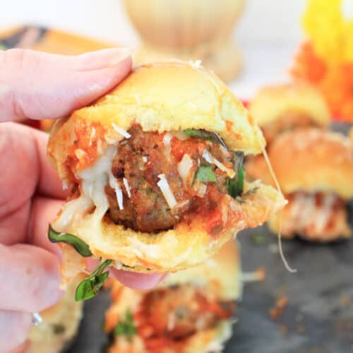 Holding a meatball slider over tray.