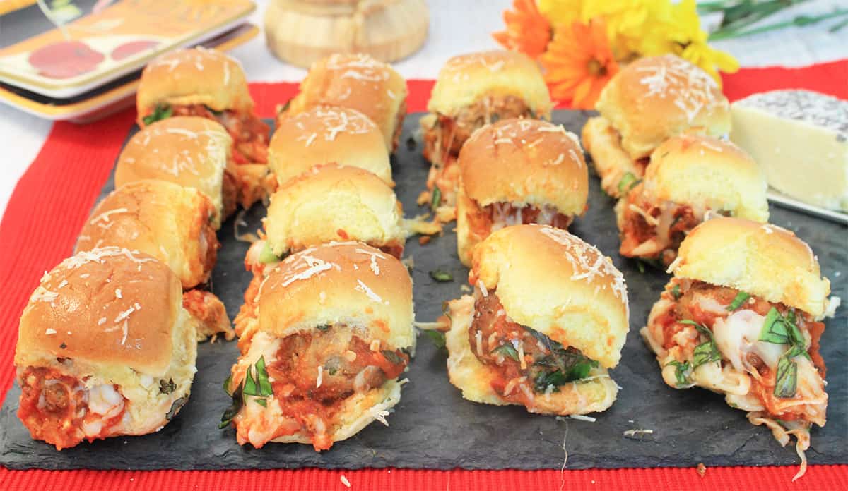 Tray of lined up hot meatball sliders.