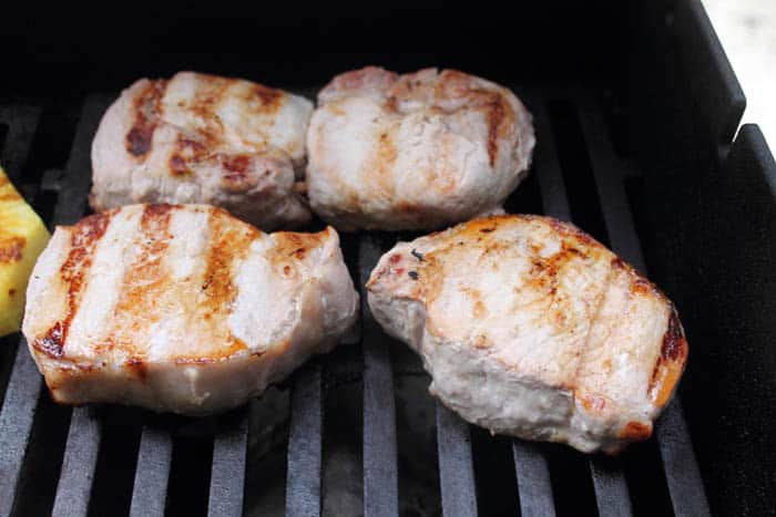Pork chops on the grill showing sear marks.