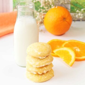 Orange creamsicle cookies stacked by milk bottle.