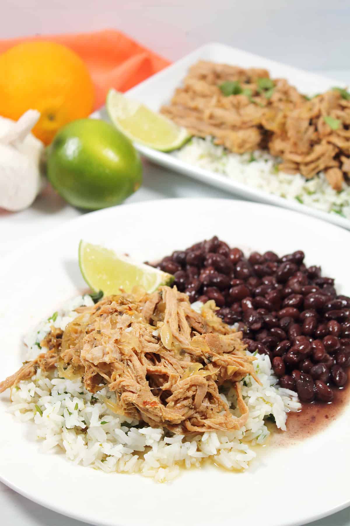 Cuban Pork dinner plated over rice with black beans.