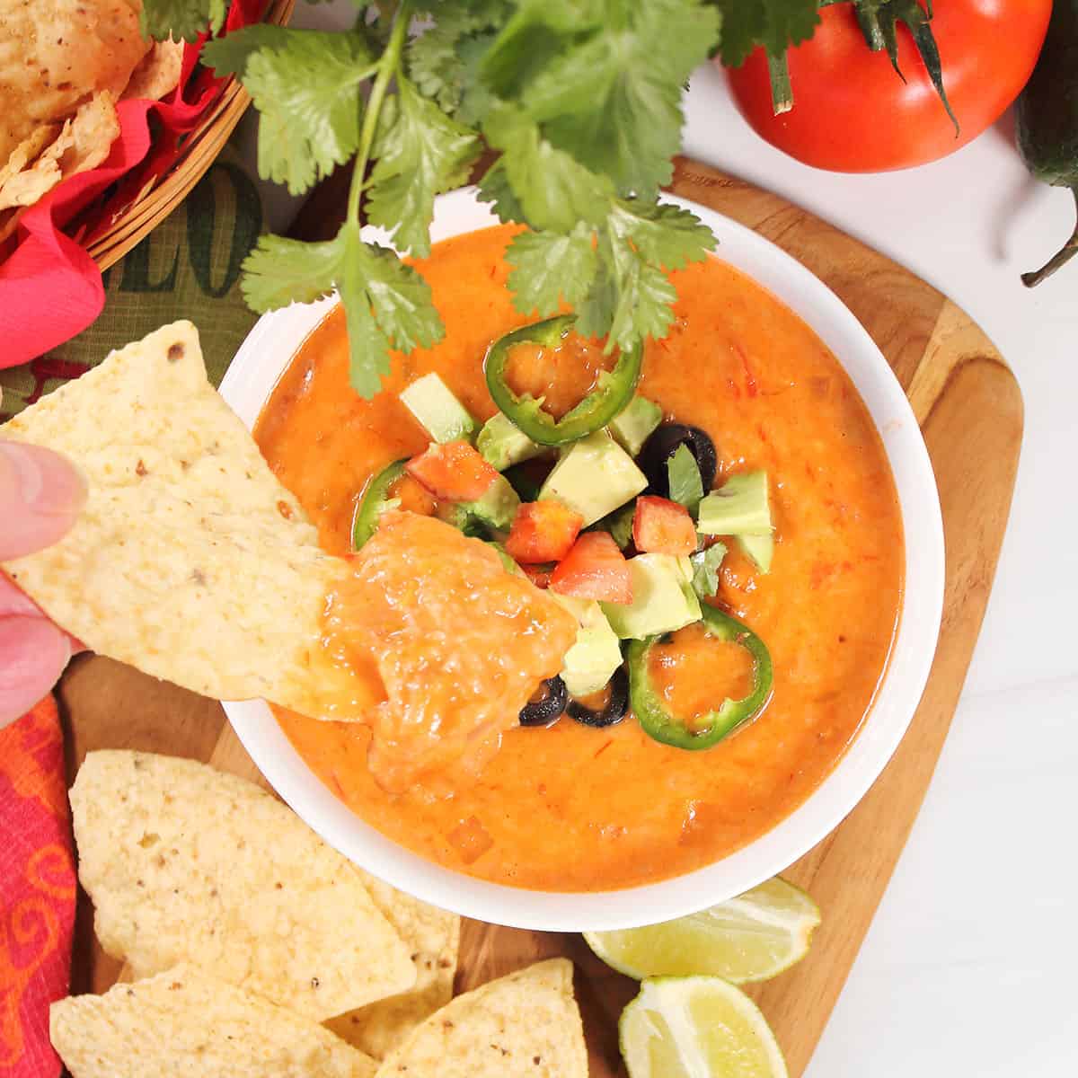Tortilla chip dipped into spicy cheese dip.