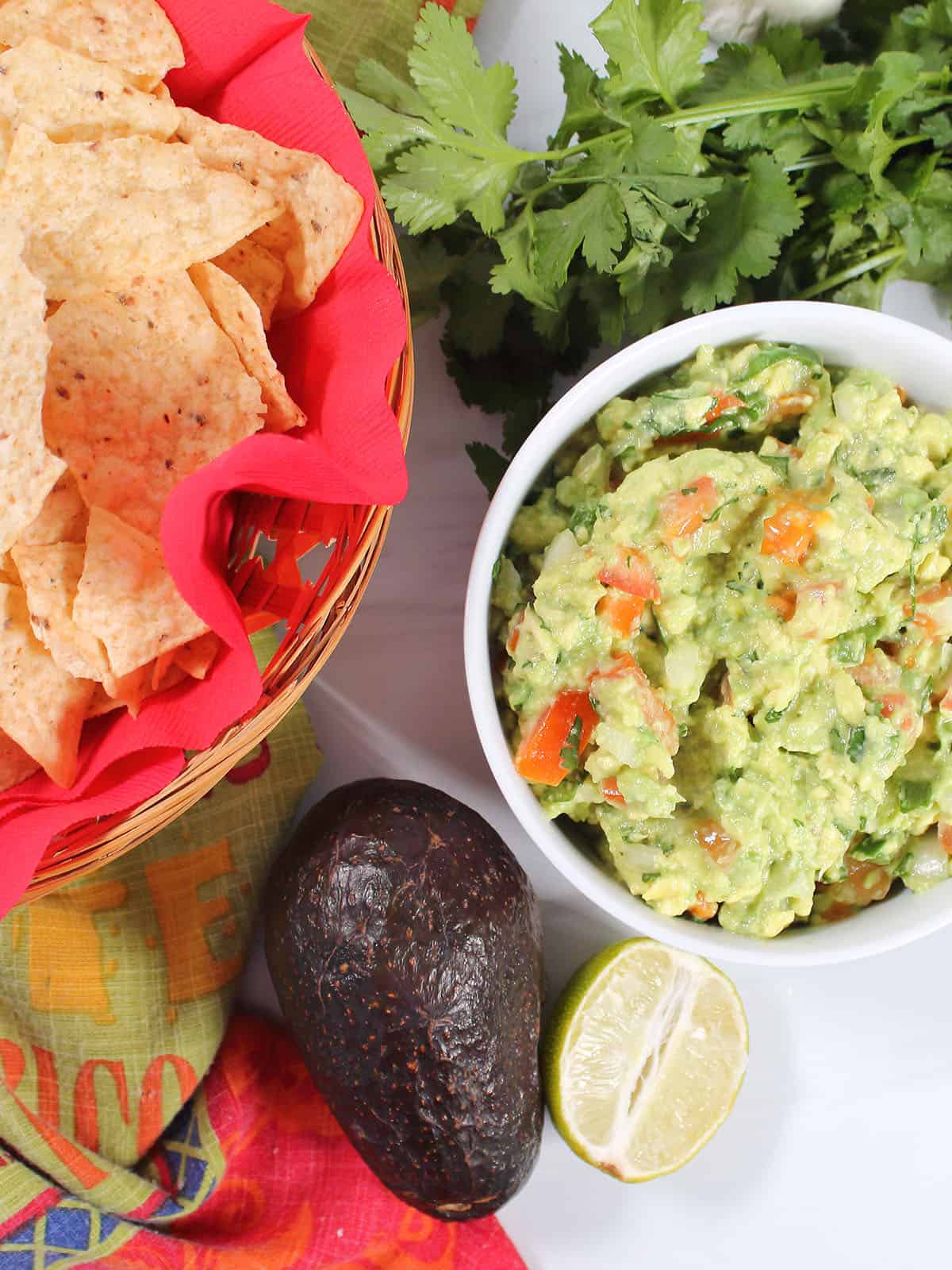Chunky guacamole in bowl next to chips.