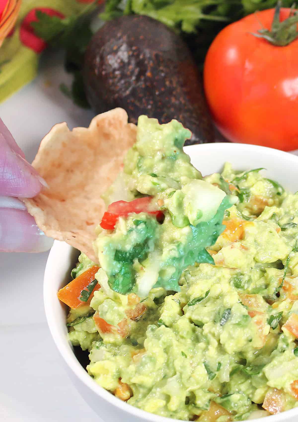 Scooping guacamole with a chip.