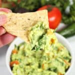 Dipping chip into avocado guacamole.