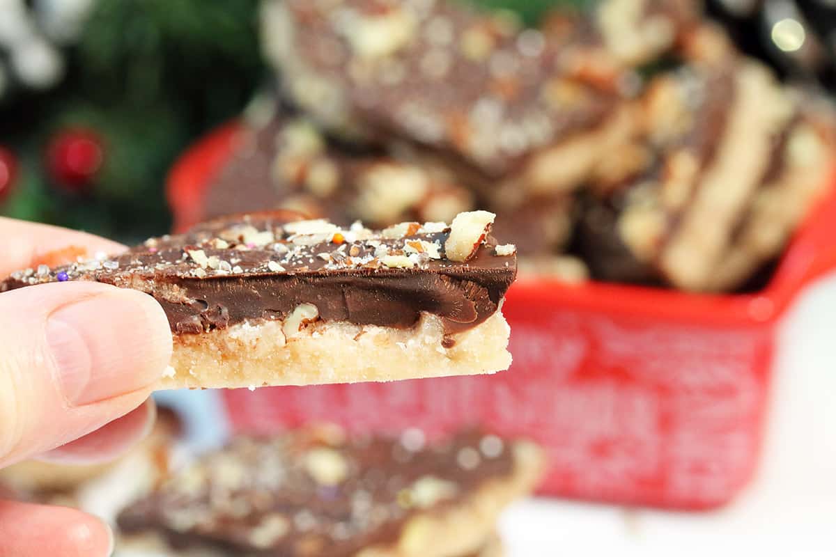 Holding piece of toffee with pecans showing layres.