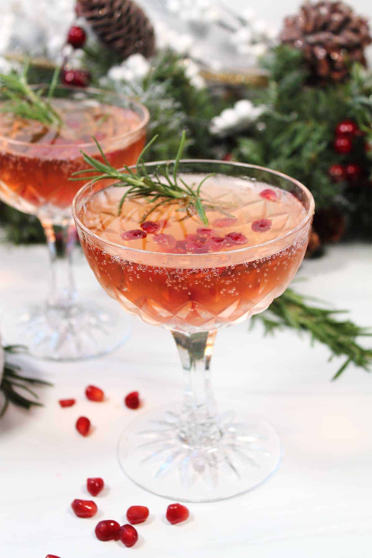 Single champagne pomegranate cocktails with scattered arils.