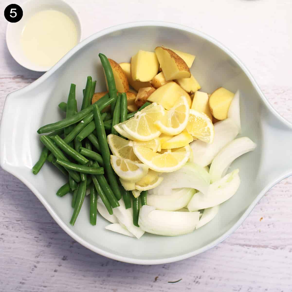 Cut up vegetables, potatoes and lemons in bowl.