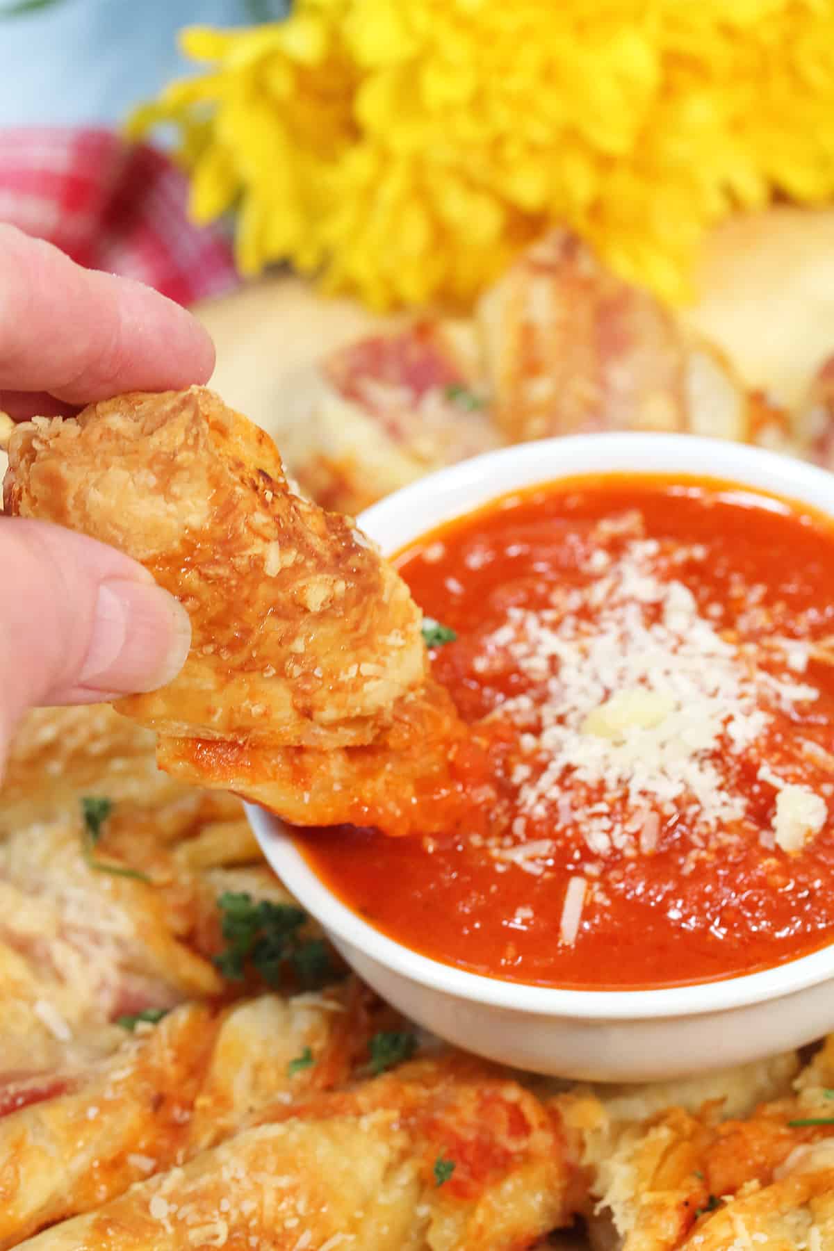 Dipping bacon twist in marinara.