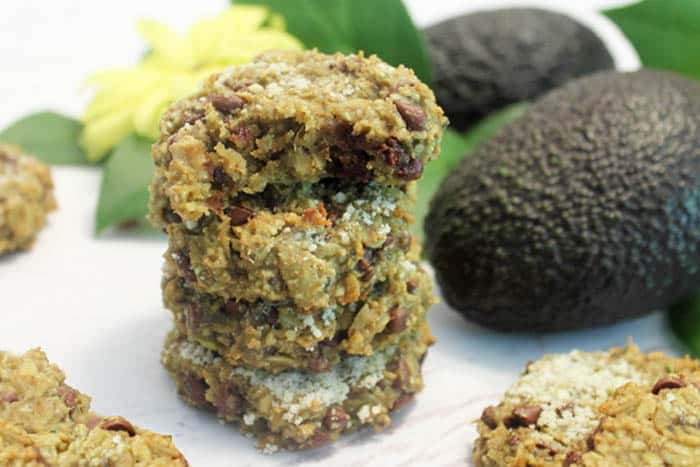 Avocado Oatmeal Chocolate Chip Cookies in a stack next to avocados