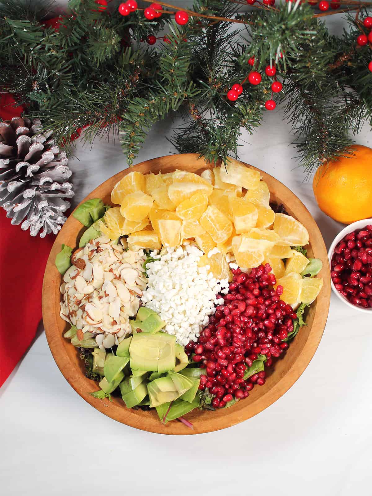 Individual salad ingredients over greens in salad bowl.