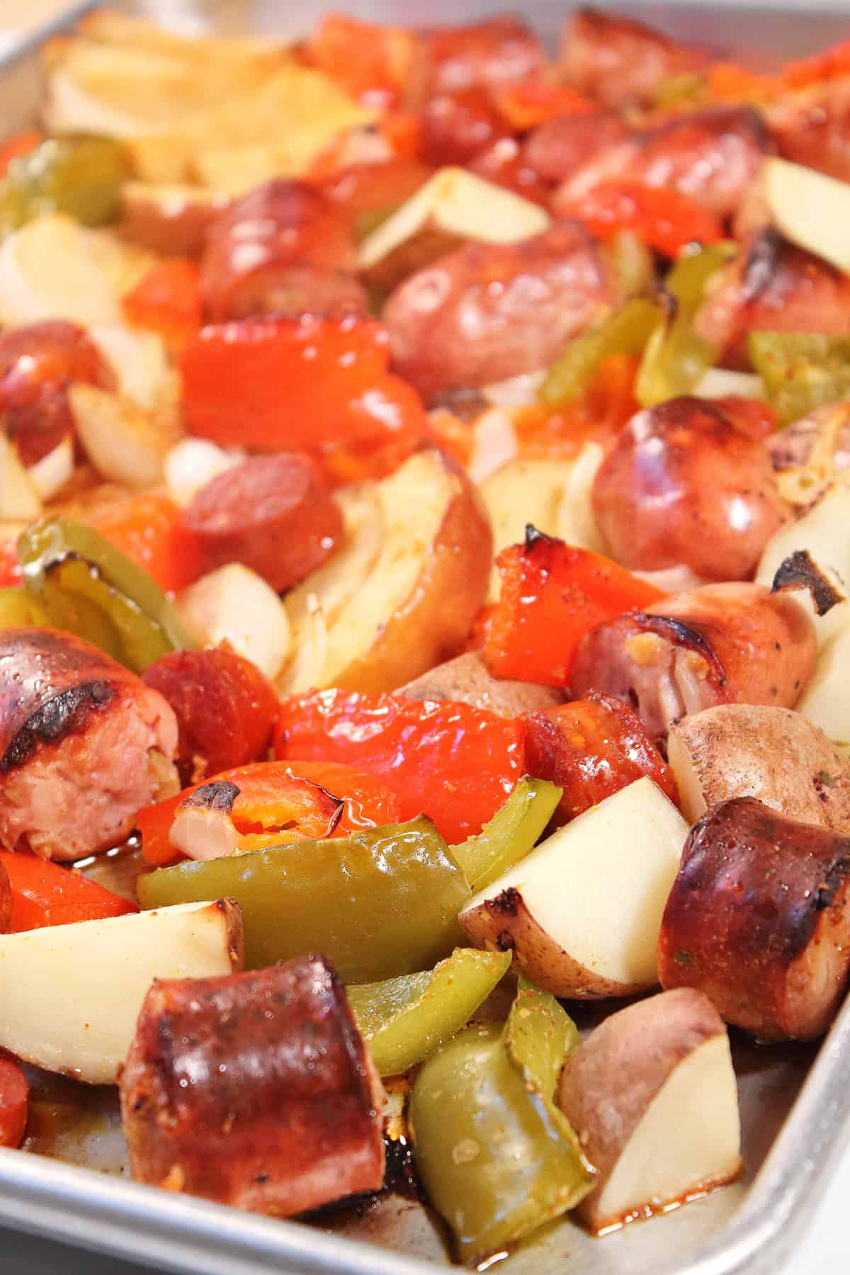 Closeup of cooked sheet pan sausage peppers and potatoes.