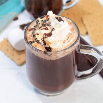 Garnished coffee with whipped cream, chocolate syrup and graham crumbs.