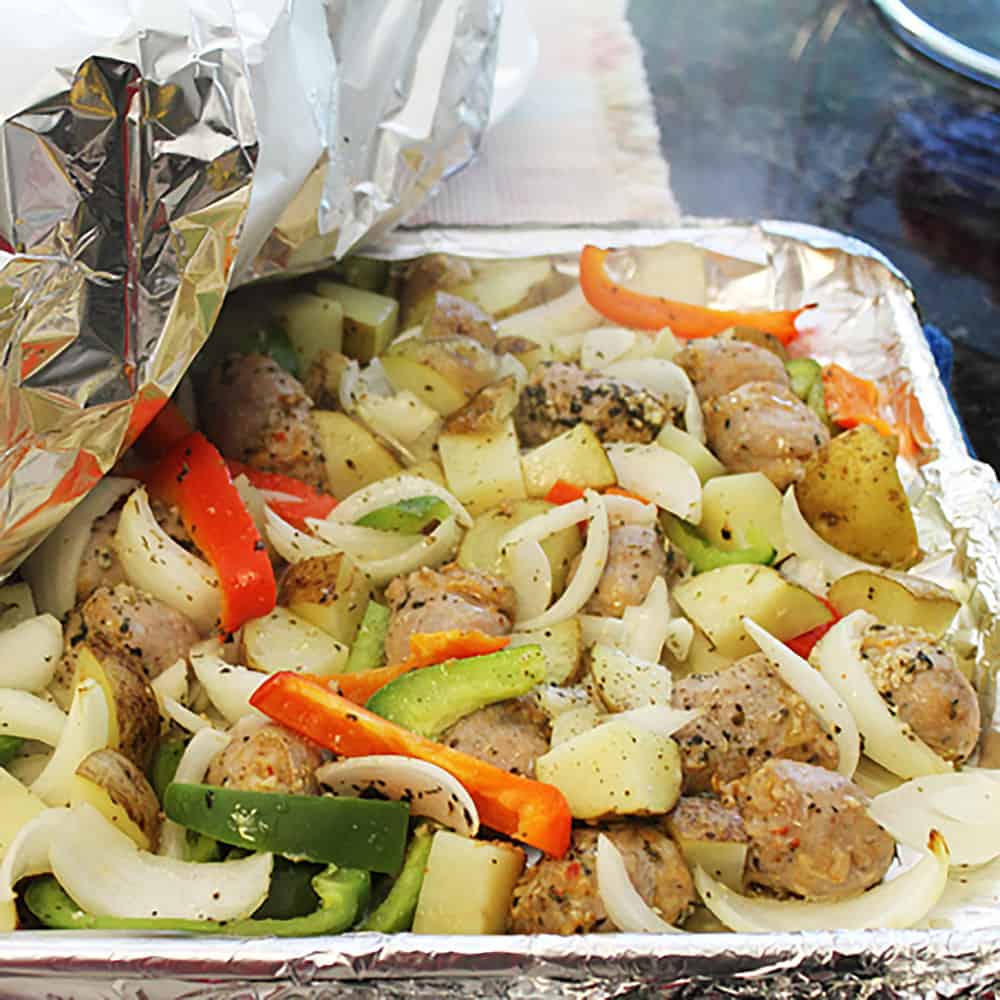 Removing foil from top of cooked dinner.