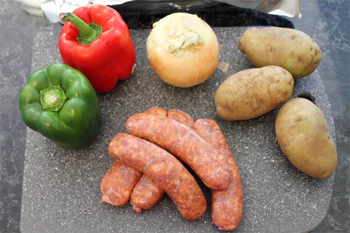 Sheet Pan Dinner ingredients or peppers, onions, potatoes and Italian sausage.