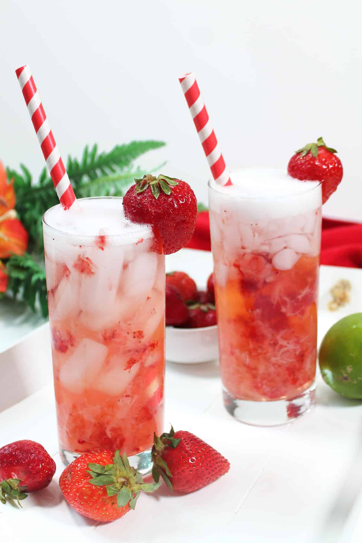 Two Strawberry Cocktails with strawberries around.
