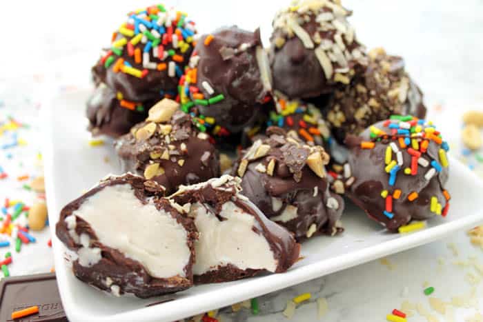 Ice Cream bites on white plate with one cut open.