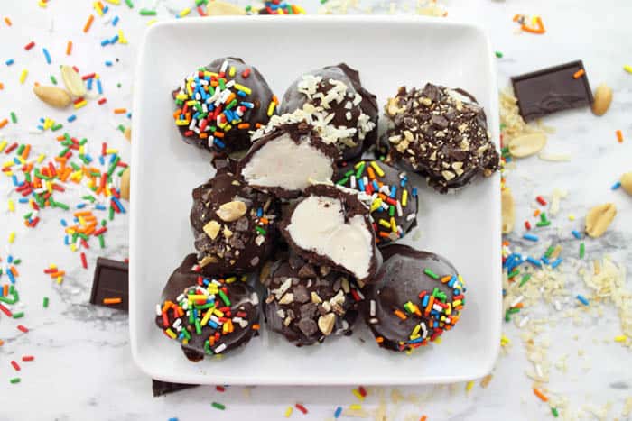 Chocolate Dipped Ice Cream piled on white plate with one cut open.