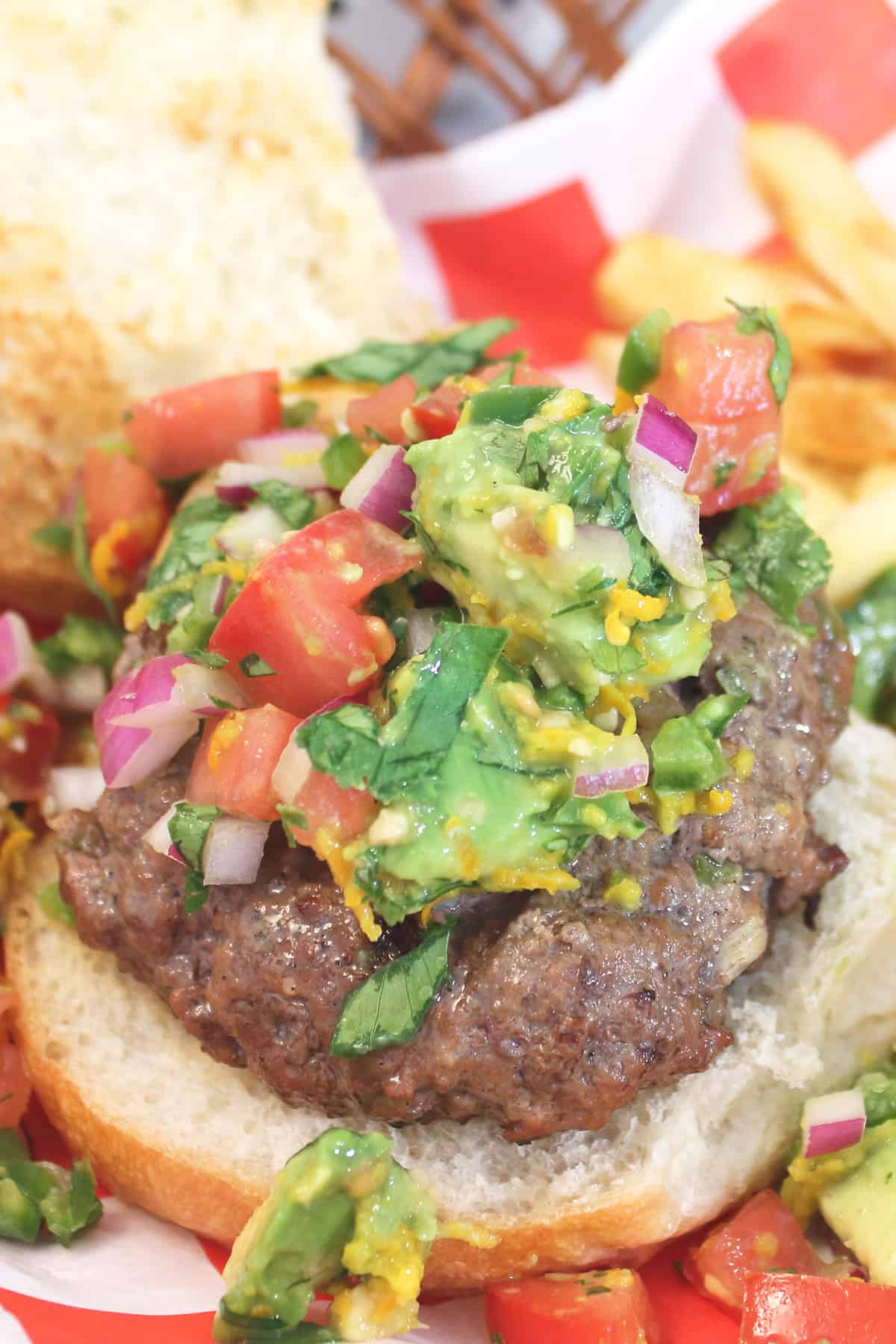 Overhead of burger with salsa and fries in basket.