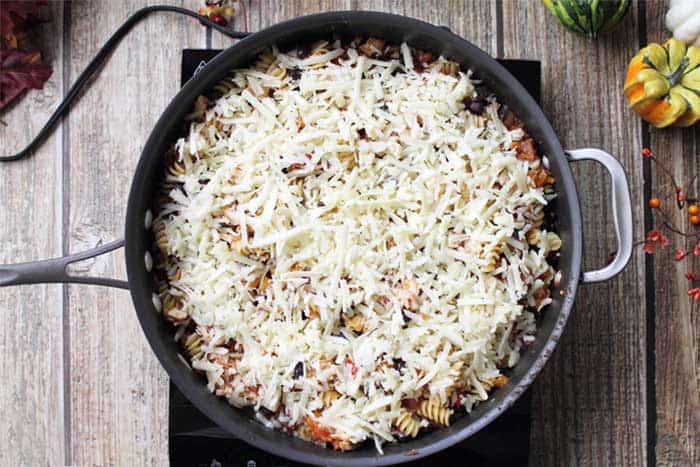 overhead of taco pasta in skillet sprinkled with cheese 