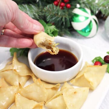 Dipping wonton appetizer in soy-flavored dip.