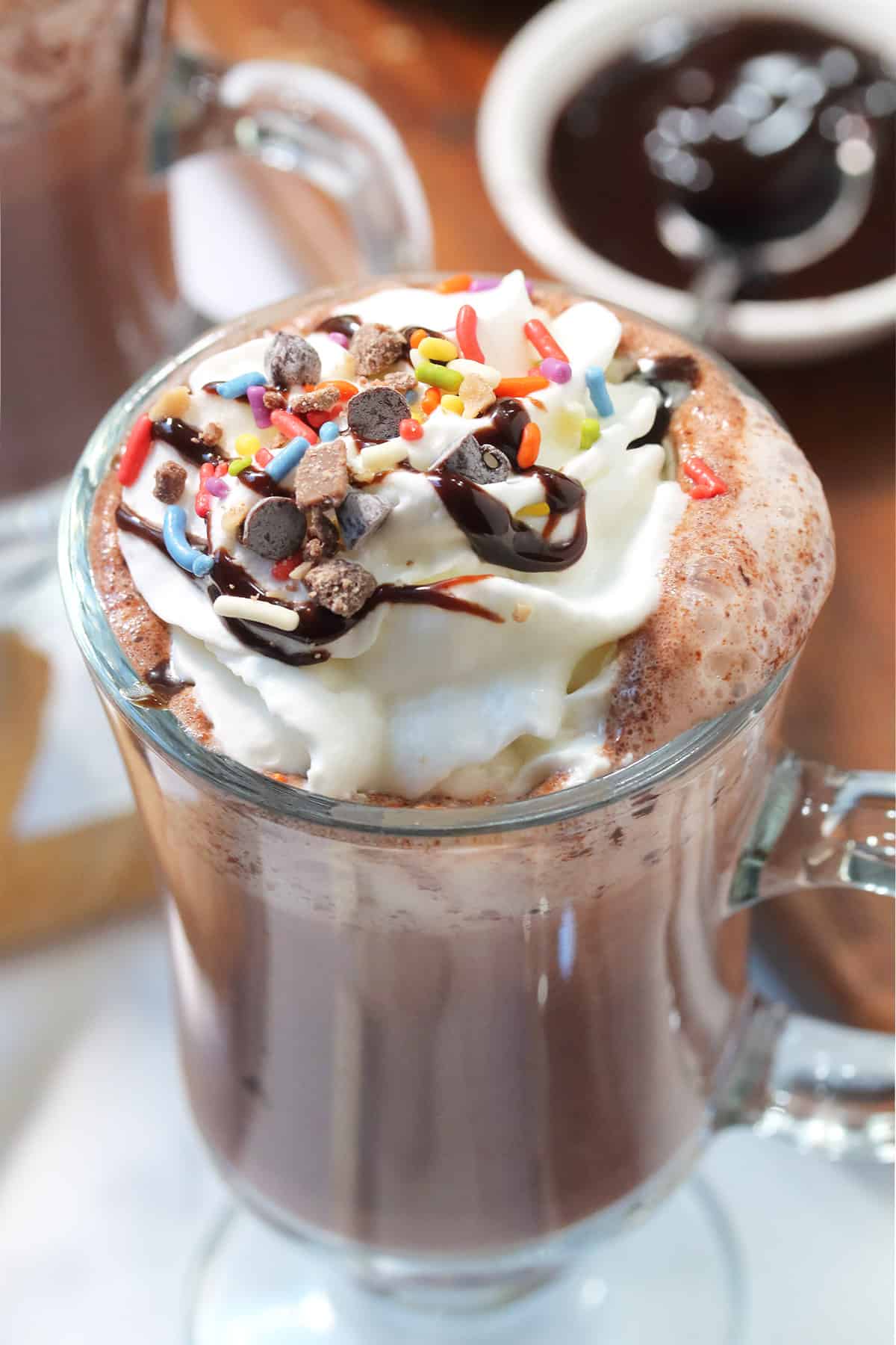 Closeup of hot chocolate topped with whipped cream and chocolate syrup.