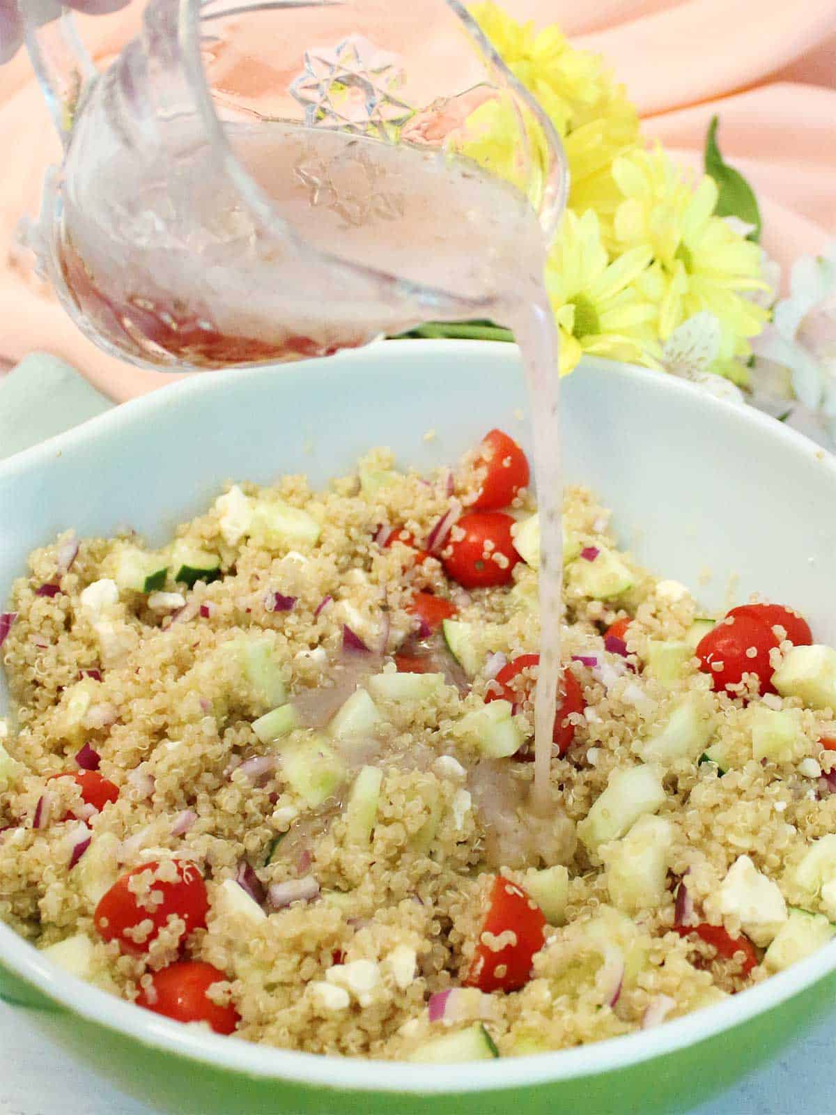 Pouring dressing on quinoa salad.