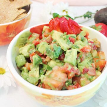 Closeup of salsa in bowl with strawberry garnish.