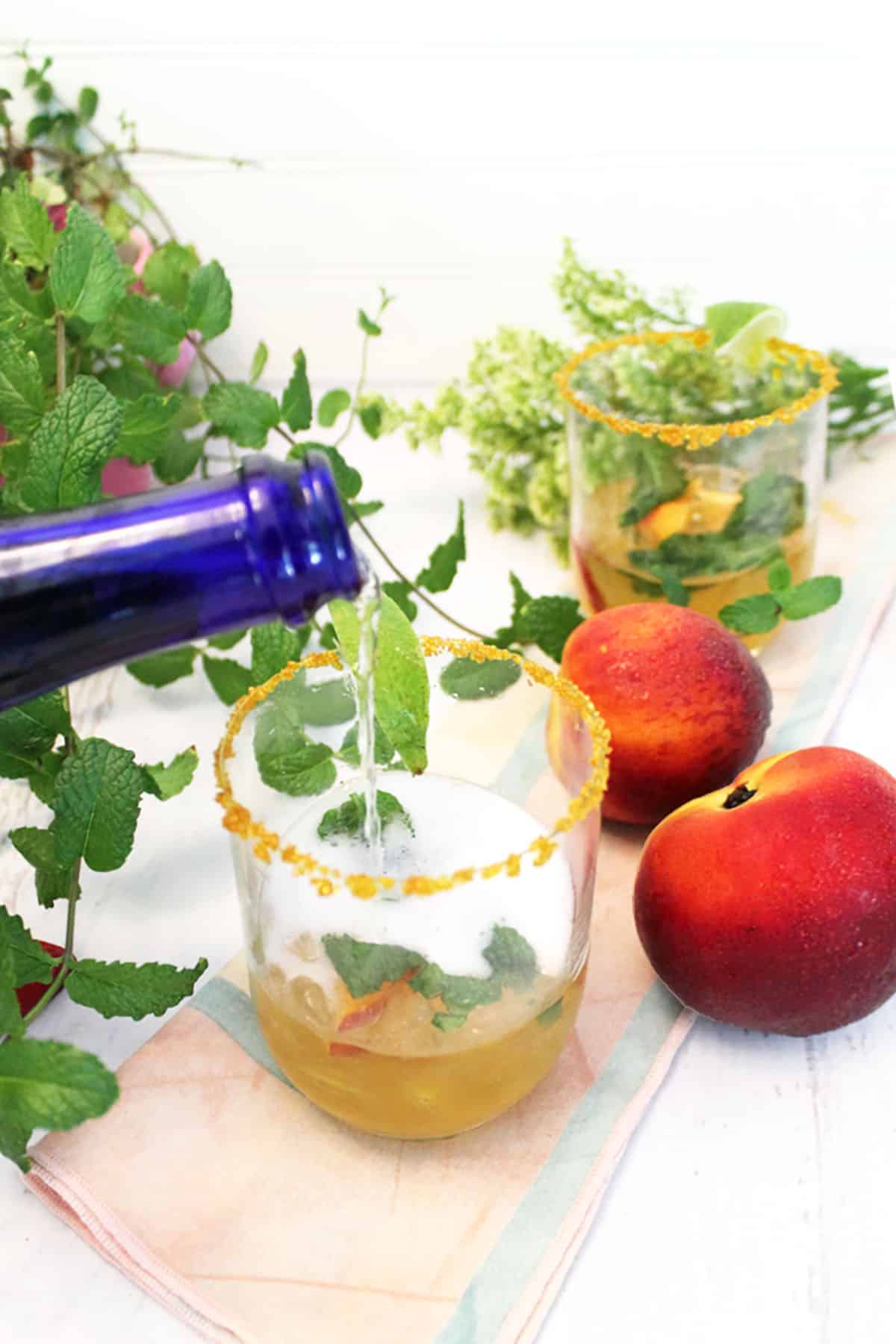 Pouring prosecco into glass with sugar rim and basic julep mixture.