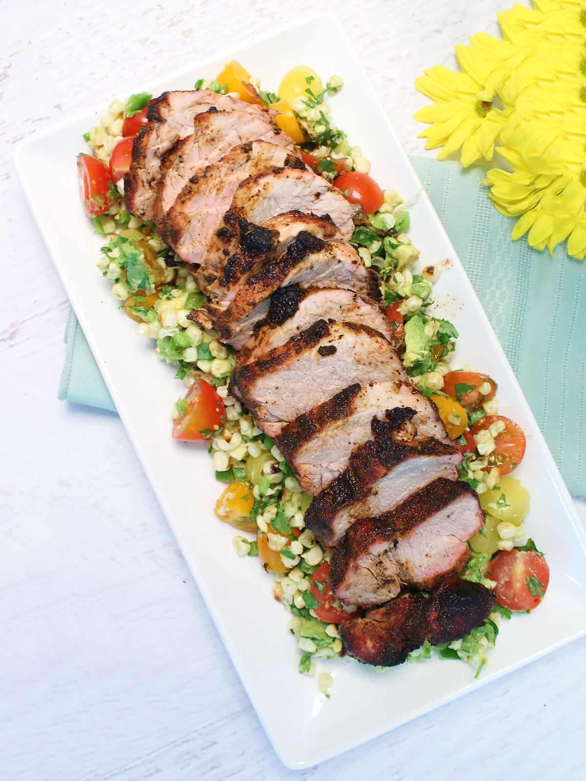 Sliced grilled pork tenderloin on platter.
